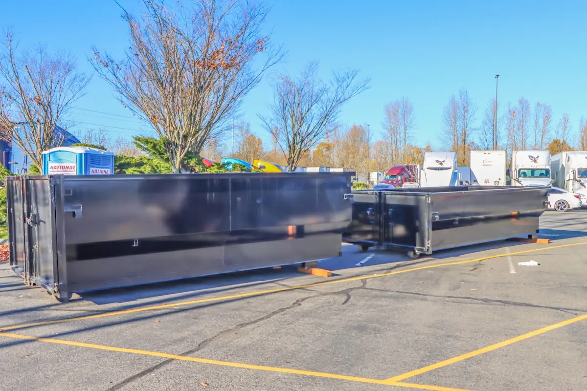 Professional dumpster rental service with roll-off container on residential driveway in Pantops